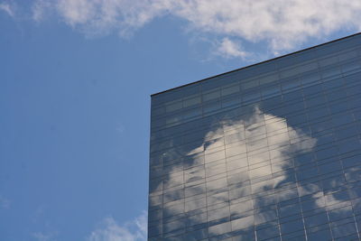 Low angle view of glass building against sky