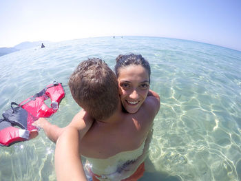 High angle portrait of smiling couple in sea