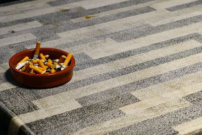 Close-up of cigarette butts in ashtray on table