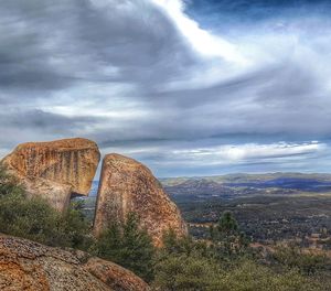 View of rock formation against cloudy sky