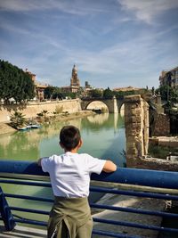 Rear view of woman standing by railing