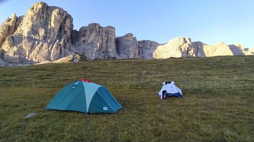 Tent on field by mountain against sky