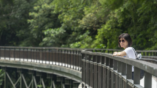 Portrait of woman on brudge against footbridge