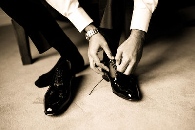 Low section of man wearing shoes at home