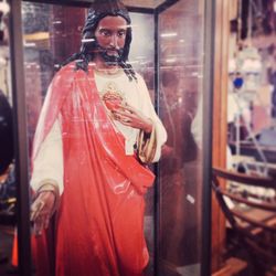 Statue of jesus christ in shop seen through glass