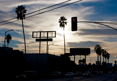 Low angle view of street lights against sky at sunset