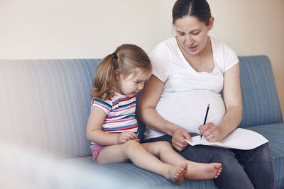 Mother with daughter on sofa