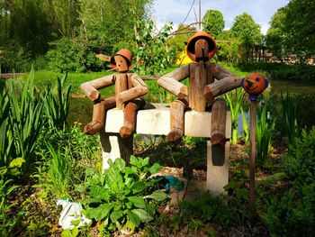 Wooden dummies amidst plants at park