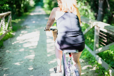 Rear view of woman walking on road