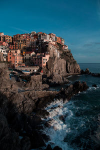 Scenic view of sea by buildings against sky