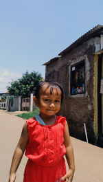 Portrait of boy standing against built structure