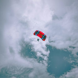 Low angle view of man skydiving against sky