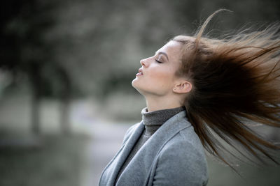 Portrait of young woman looking away outdoors