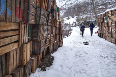 Rear view of hikers walking on snow covered field