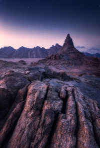 Scenic view of rocky mountains against sky at night