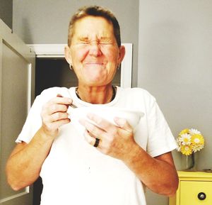 Portrait of man holding ice cream at home