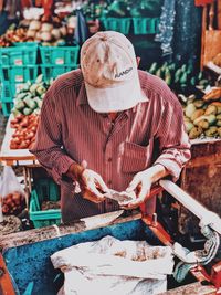 Full length of man eating food at market stall