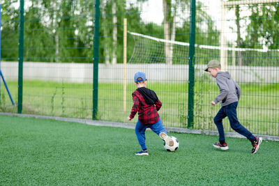 Children play football in the yard, on the lawn