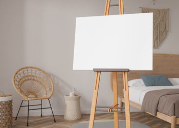 Empty horizontal canvas on wooden easel in modern and cozy room. mock up interior