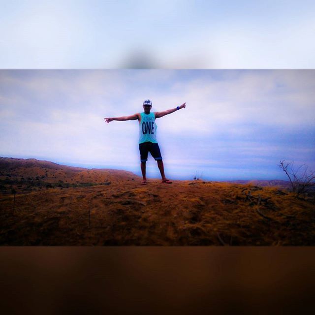 full length, lifestyles, leisure activity, arms outstretched, casual clothing, sky, standing, landscape, freedom, mid-air, tranquil scene, rear view, cloud - sky, young adult, getting away from it all, jumping, nature, tranquility