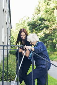 Woman standing by railing against people