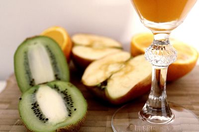 Close-up of fruits and drink on cutting board