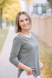 Beautiful middle age caucasian woman with short hair walking in autumn fall street outdoors. 