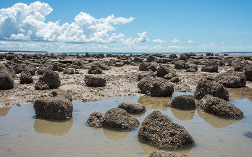 Panoramic view of rocks on beach against sky