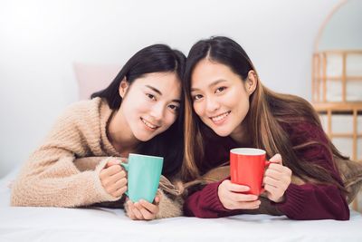 Portrait of happy young woman with coffee cup