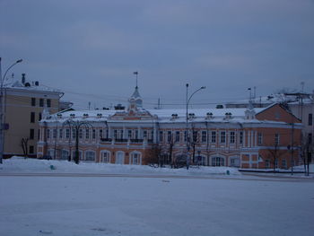 Snow covered houses and buildings against sky