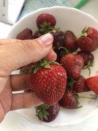 Close-up of hand holding strawberries