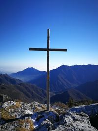 Cross on mountain against clear blue sky