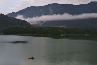 Scenic view of lake by mountains against sky