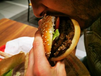 Midsection of person holding cheese burger 