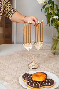 Cropped hand of woman holding wineglass on table