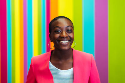 Portrait of young woman standing against wall