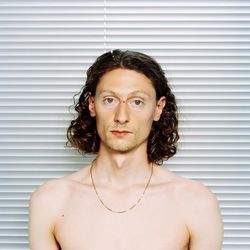 Portrait of handsome young man standing against wall