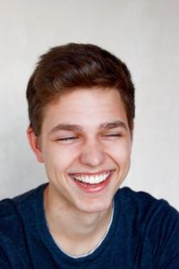 Close-up portrait of a smiling young man over white background