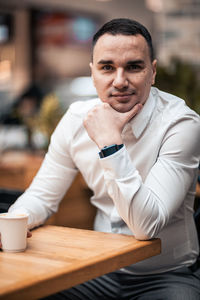 Portrait of man sitting at table in cafe