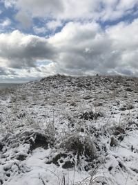 Scenic view of snow covered land against sky