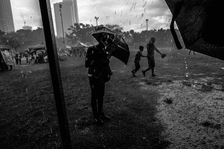 PEOPLE WALKING ON WET STREET IN CITY