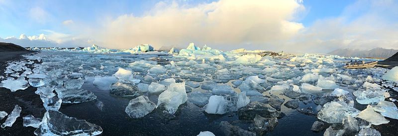 Panoramic view of frozen lake against sky