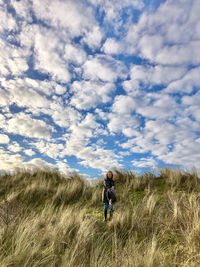 Rear view of man on field against sky