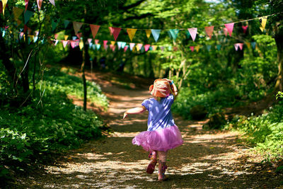 Rear view of girl running on footpath