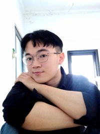 Portrait of young woman sitting on sofa at home