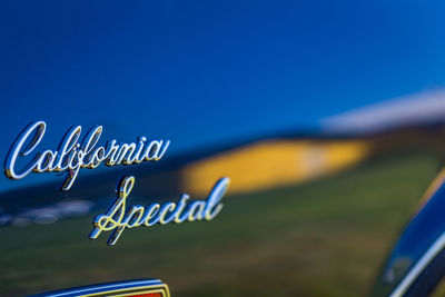 Close-up of information sign against clear blue sky