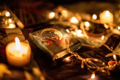 Close-up of lit candles on table