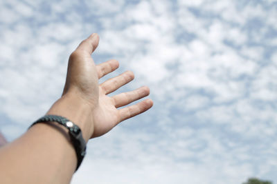 Close-up of person hand against sky