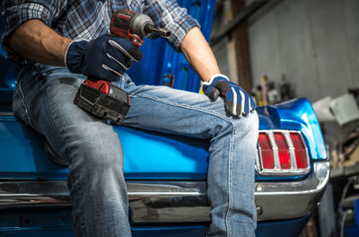 Low section of man working on car