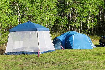 Tent on field against trees in forest